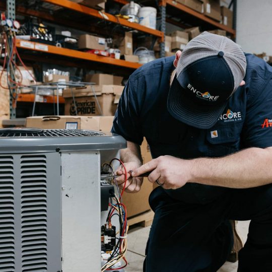 HVAC technician repairing air conditioner in Carver, MN home.